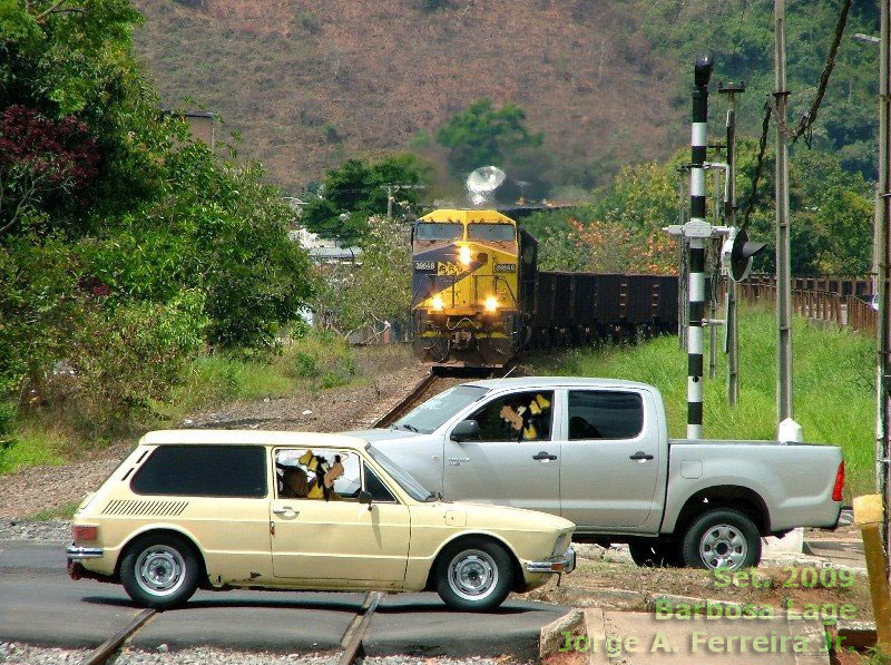 Motoristas insistindo em cruzar os trilhos do trem, enquanto a locomotiva se aproxima com dezenas de vagões