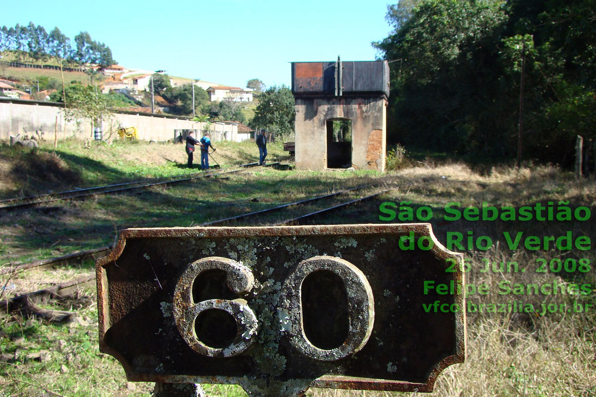Caixa d'água da estação ferroviária de São Sebastião do Rio Verde vista desde a estação, durante a capina para operação do Trem das Águas