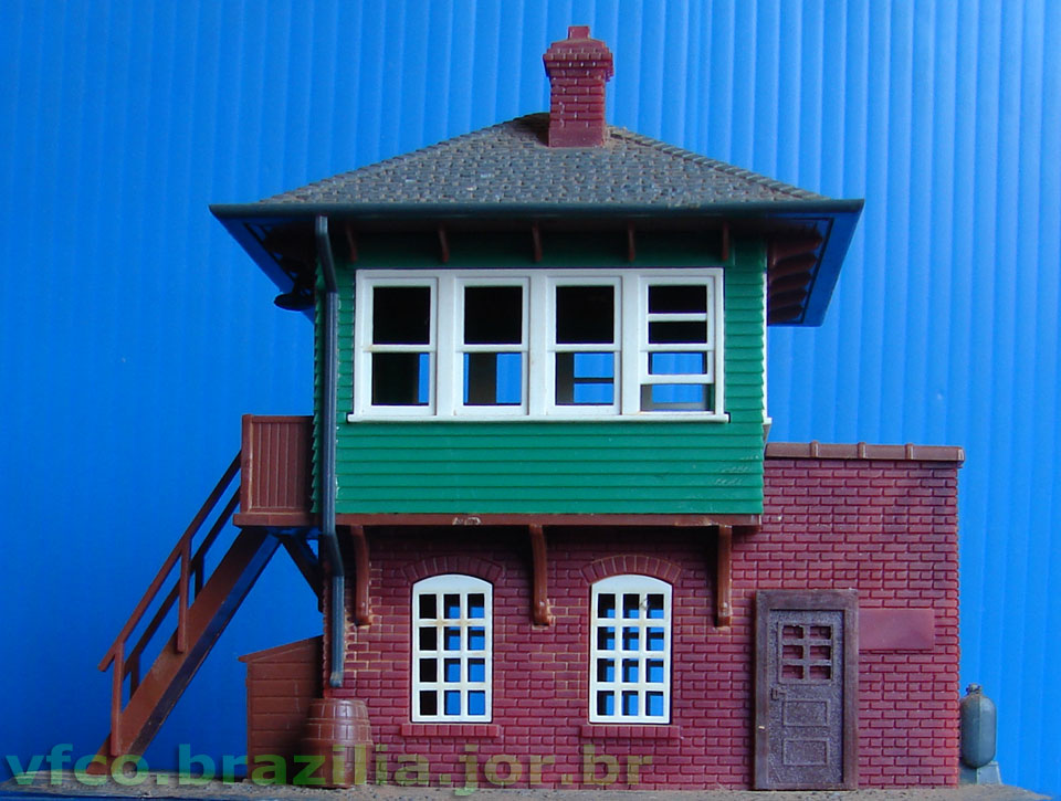 Porta com postigo da Miniaturas Artesanais, para maquete de ferreomodelismo, comparada às janelas da torre de sinalização ferroviária da Atlas