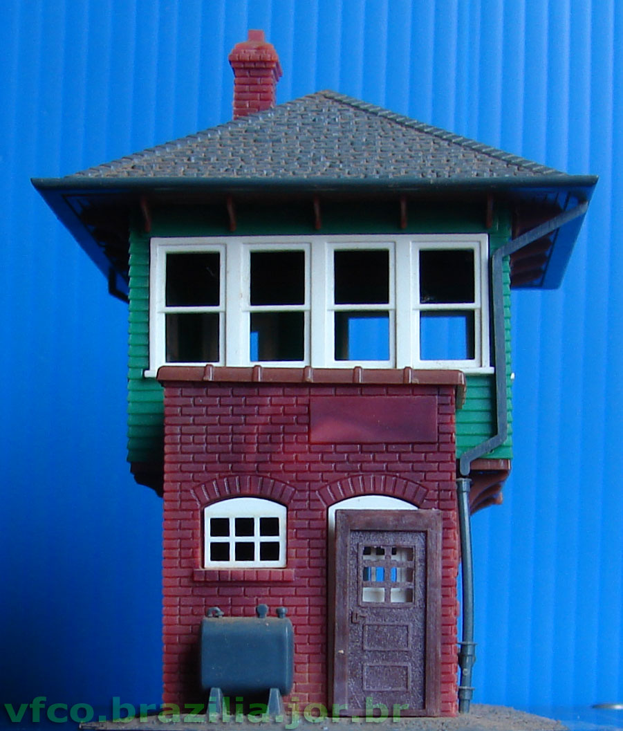 Porta com postigo de vidro da Miniaturas Artesanais, disposta em frente à cabine de sinalização ferroviária da Atlas para comparação