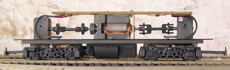 Ferreomodelo de locomotiva Frateschi sem a casca, mostrando o motor, cardã de transmissão, truques redutores,  fiação, circuito impresso e micro-lâmpadas, de perfil