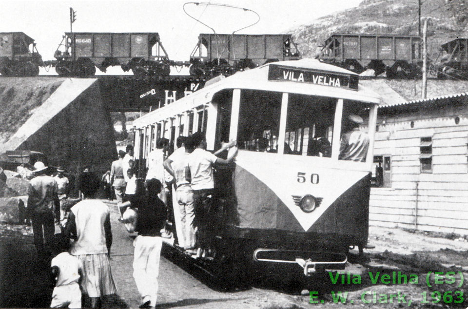 Bonde de Vila Velha (ES) em 1963, passando sob um trem de minério — da Leopoldina, segundo o autor, embora as gôndolas MG estampem o emblema da CVRD