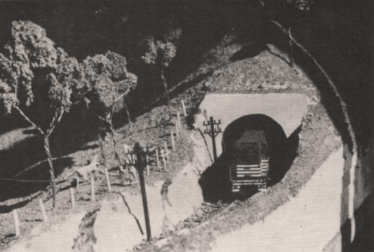 Detalhe da locomotiva saindo do túnel em um corte num canto da maquete
